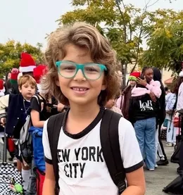 Bond, a curly-haired boy with turquoise glasses and a New York City t-shirt